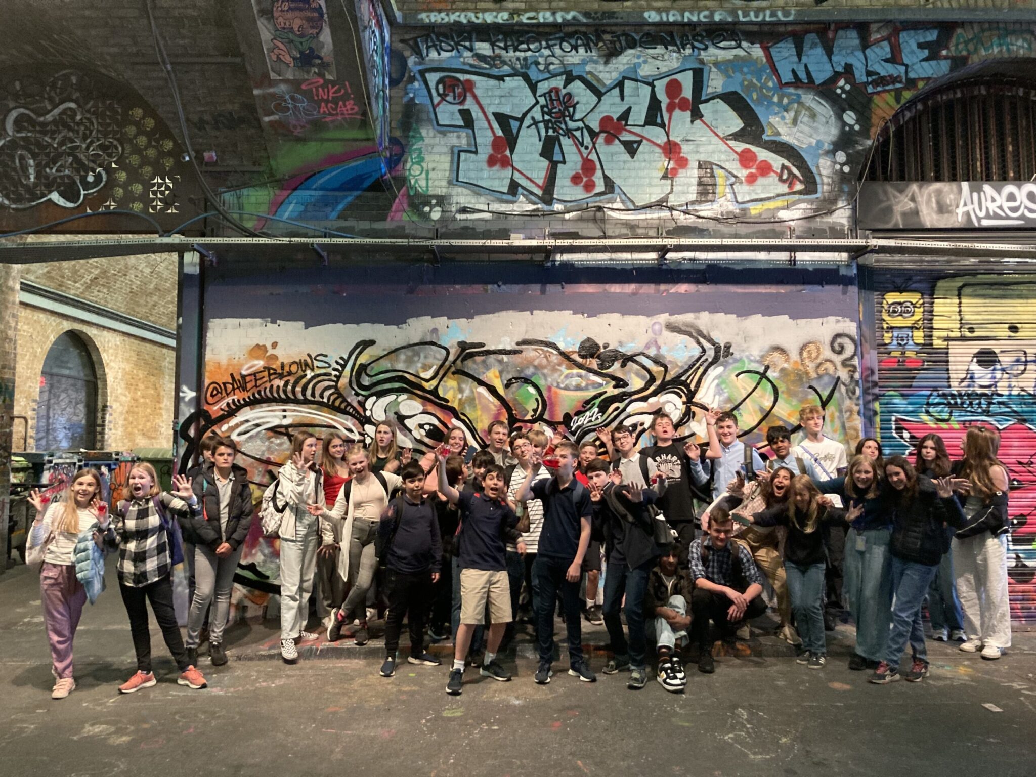pupils in front of street art work