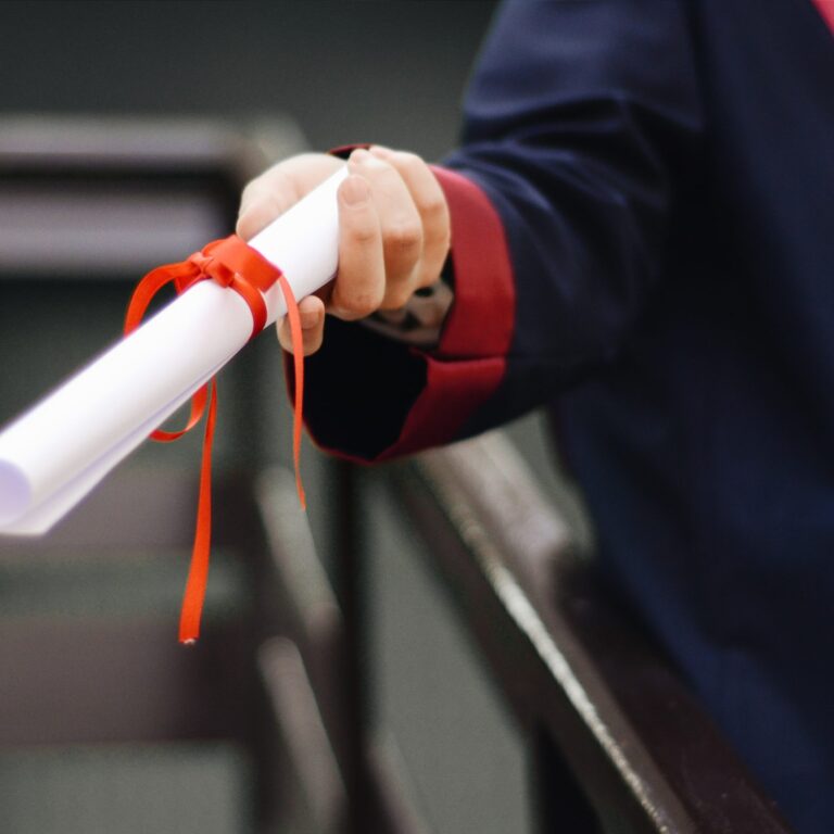 Hand holding a graduation certificate