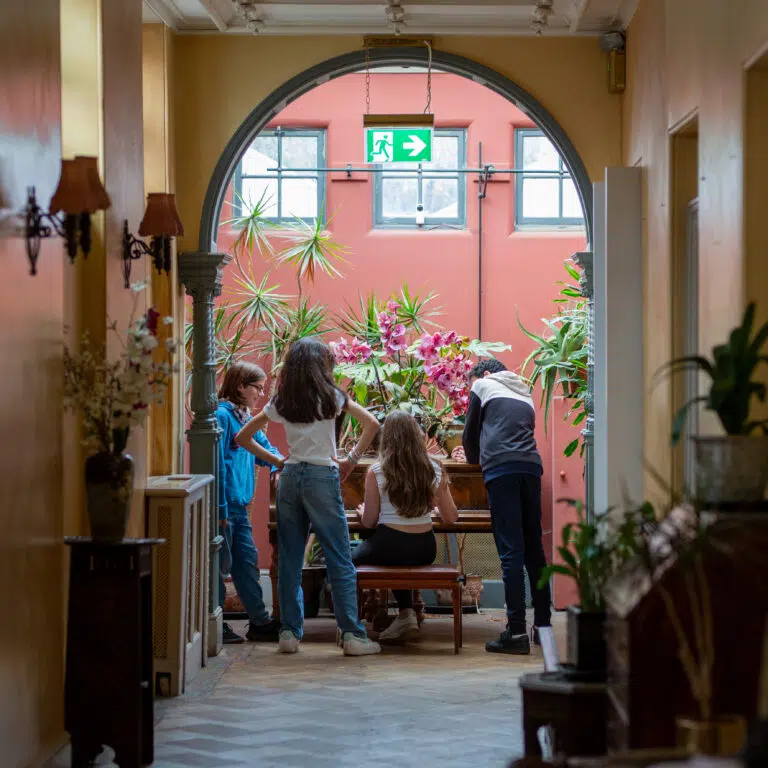 group of children gathered around a piano